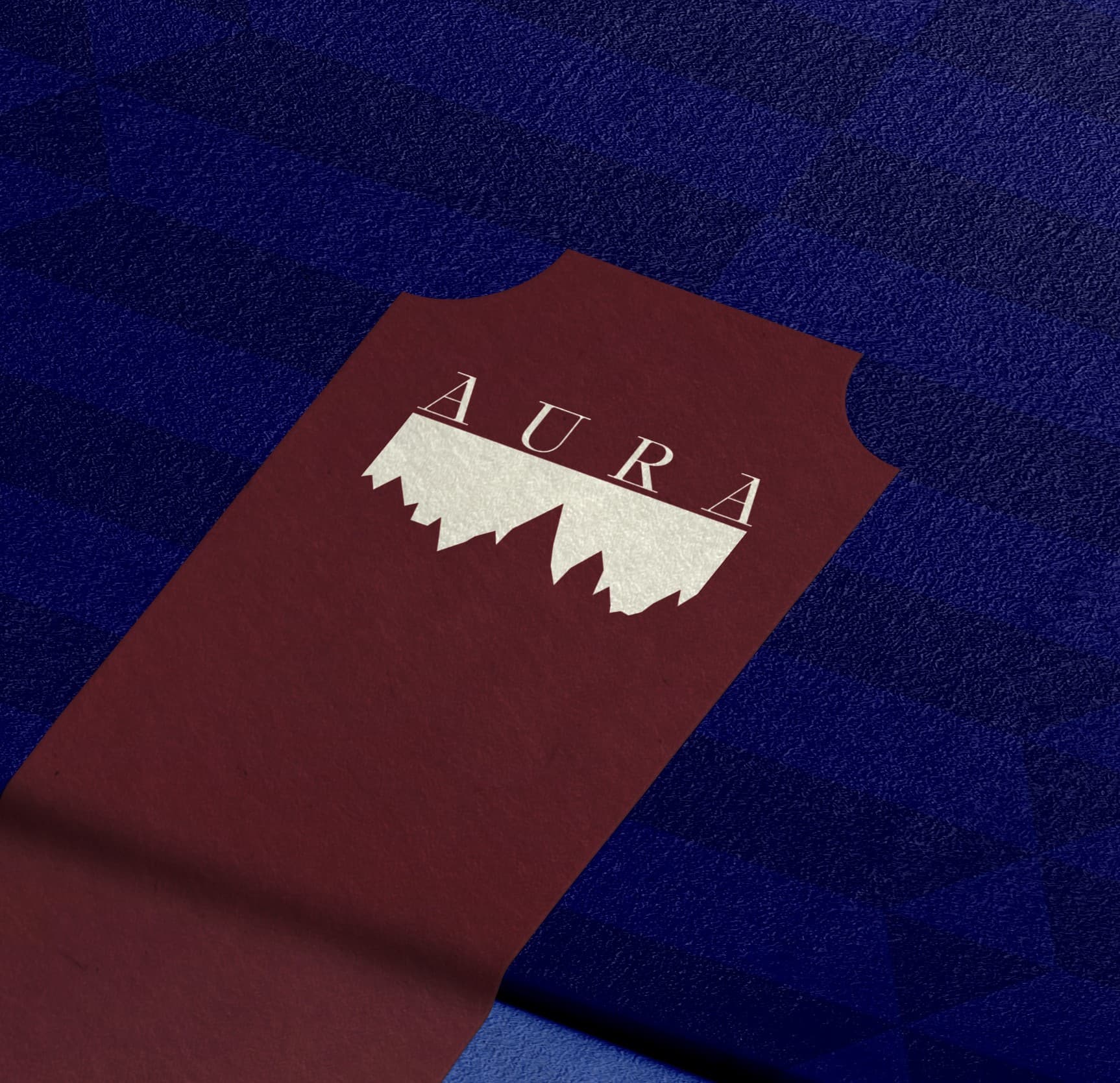 An Aura-branded card resting on dark blue fabric
