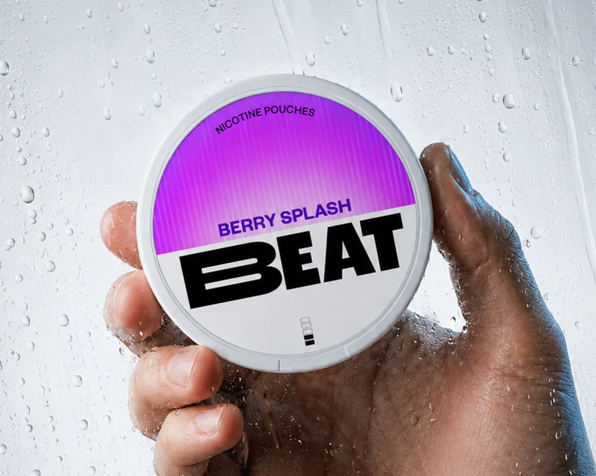 A hand holding a Beat Berry Splash nicotine pouch tin